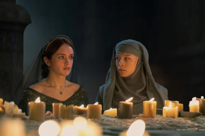 a group of women sitting around a table with candles